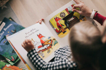 person reading a book with a child