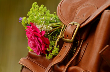 leather backpack with colorful flowers sticking out